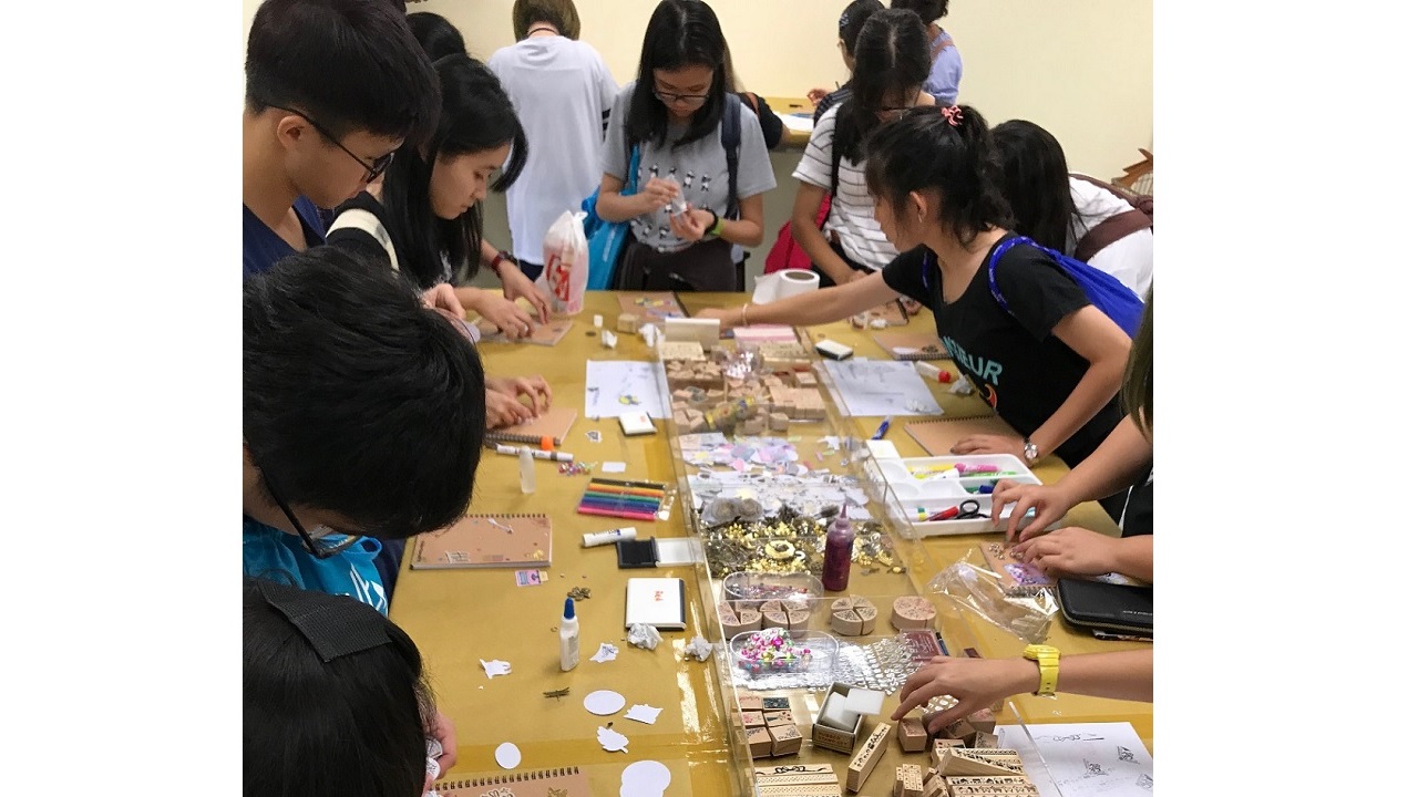 A group of students engaged in crafting activities at a table.