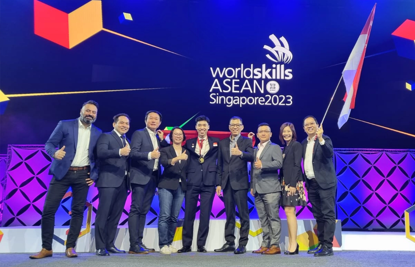 Leonard with his coaches on the WorldSkills ASEAN 2023 stage