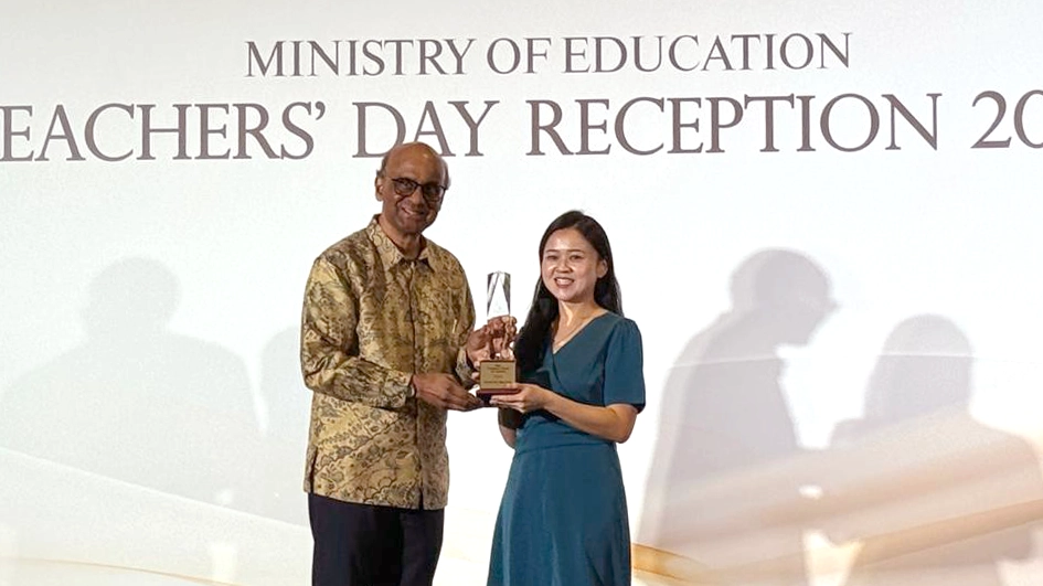 Eunice and President Tharman poses for a picture on stage.